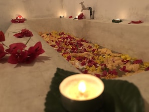 A candle-lit memorial with flowers and a deer statue. - The Retreat Hotel (Hikkaduwa)