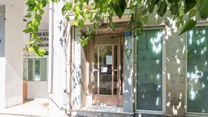 A building entrance with a glass door, a small porch, and a sign indicating the number 10. - Athens Welcome Suites Apartments (Athens)