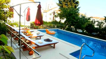 Seasonal outdoor pool, open 9:00 AM to 8:00 PM, pool umbrellas