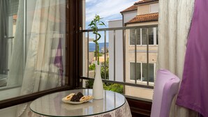 Ein Balkon mit einem Glastisch, einer weißen Vase und einem Teller Kekse.