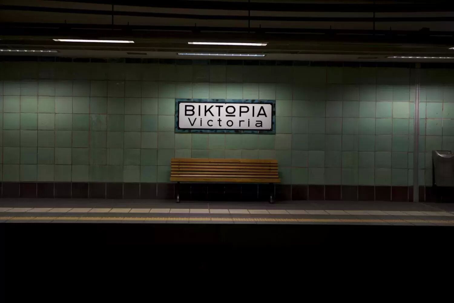 A subway station with a bench and a sign that reads "BIKTOPIA Victoria".