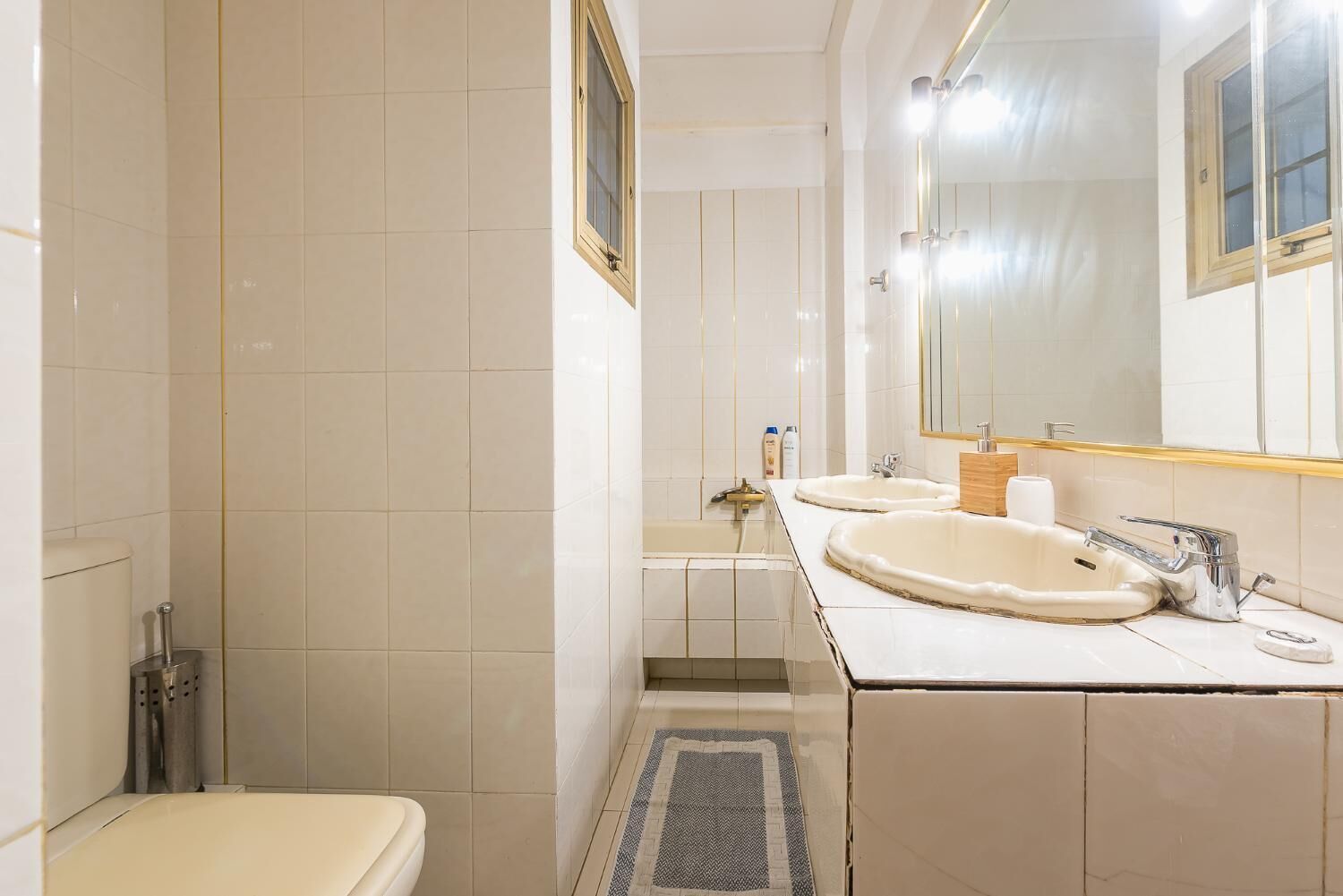 A bathroom with two sinks, a toilet, and a shower.
