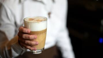 Una persona sosteniendo una taza de café con espuma.