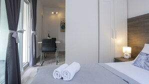 A hotel room with a bed, a nightstand with a lamp, a chair, and a desk. - Pool Apartments Privilege (Novalja)