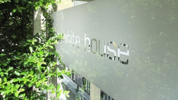 A sign with the text "white house" partially obscured by foliage. - The White House (Brighton)