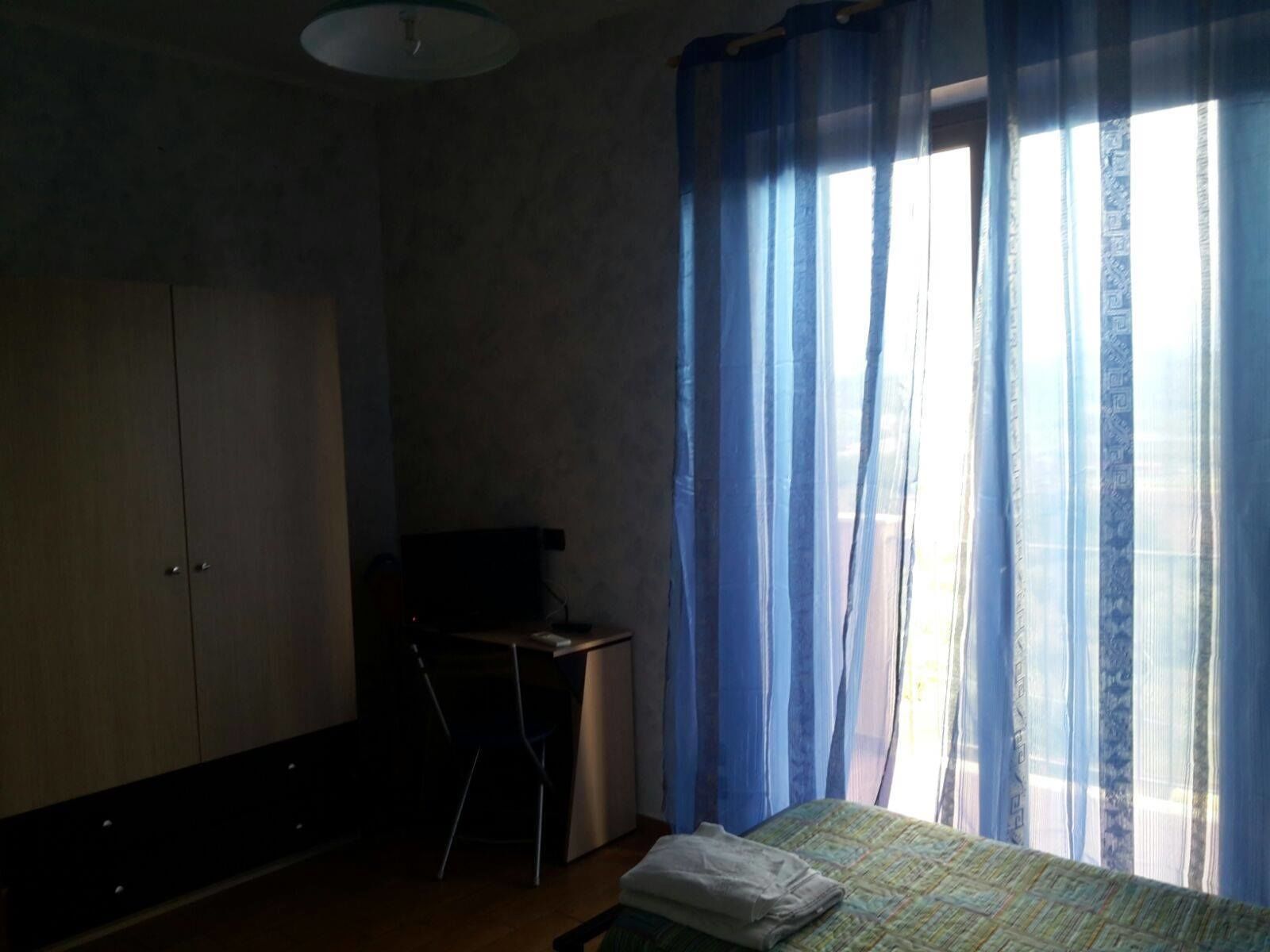 Een slaapkamer met een bed, een bureau en een kledingkast.