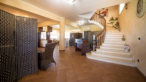 Un interior espacioso con una escalera, una mesa de recepción y una zona de estar.