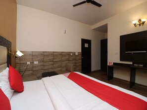 A hotel room with a bed, a television, a ceiling fan, and a wooden accent wall. - OYO 27718 Viva Destinations (Gurugram)