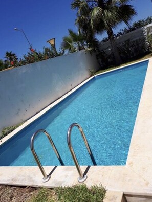 Piscine extérieure, parasols de plage, chaises longues