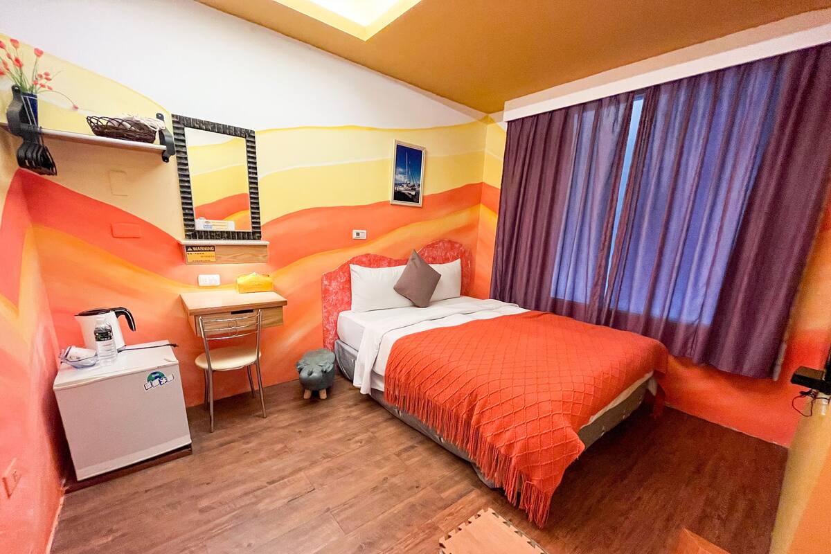Una habitación con cama, escritorio, silla y una pequeña alcancía.