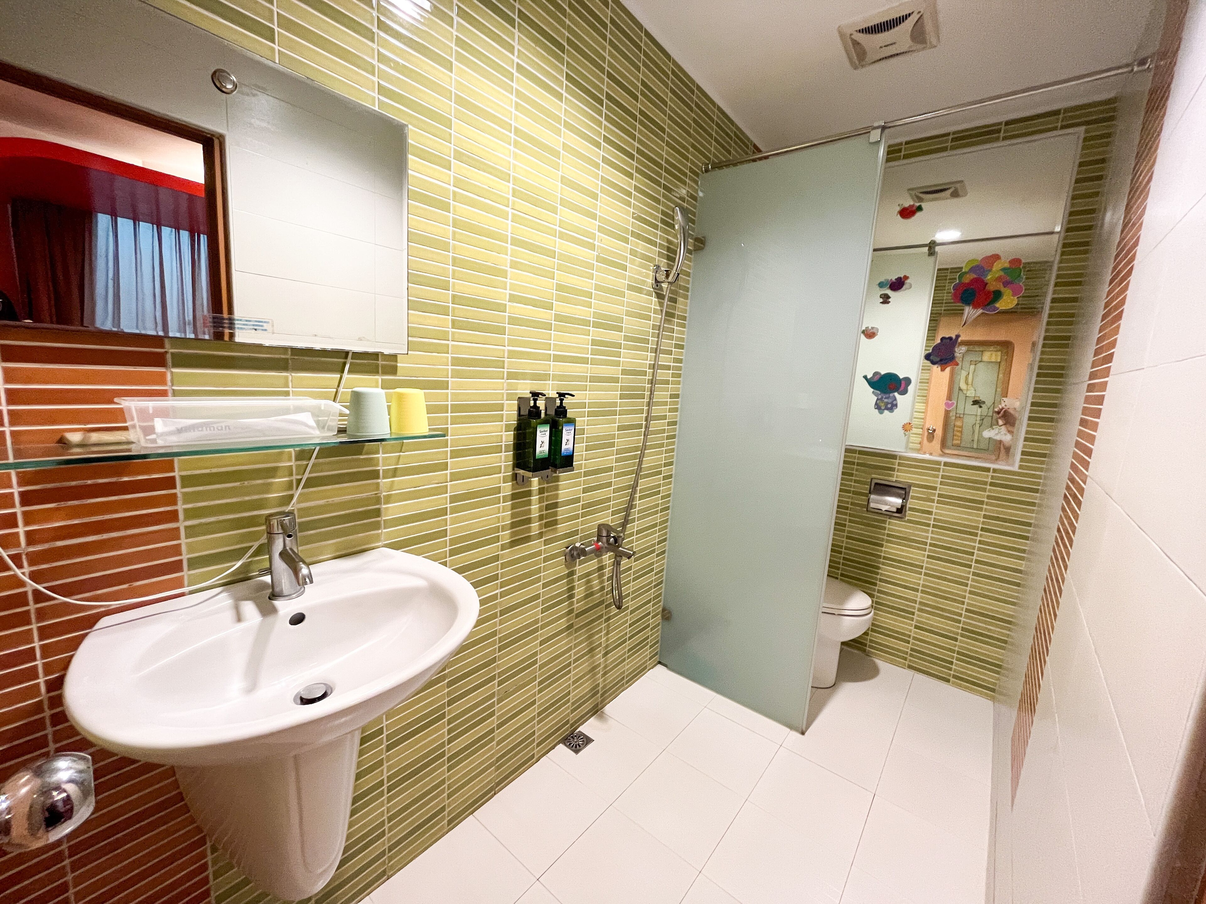 Un baño con lavamanos, espejo y ducha.