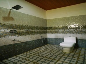 Une salle de bain avec un sol carrelé, des toilettes, une douche et un plafond avec une poutre en bois.
