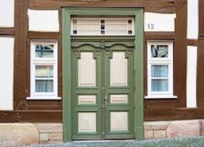 Traditional building with symmetrical design, featuring two windows and a classic central door.
