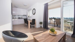A modern apartment with a kitchen, dining area, and a balcony with a view. - Apartments Villa Dalia (Novalja)