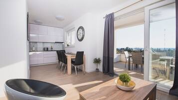 Appartement Deluxe, 2 chambres, vue sur la piscine | Aire de séjour | Téléviseur à écran plat de 55 po avec télévision par satellite