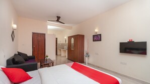 Una habitación de hotel con cama, sofá, televisión y armario.