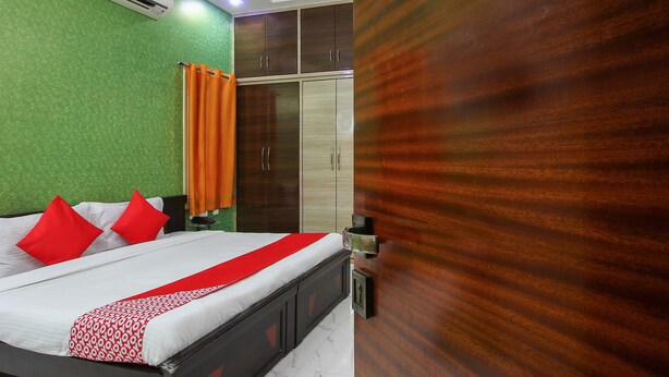 A bedroom with a bed, an air conditioner, a ceiling fan, and a wardrobe. - OYO 7571 Madhapur (Hyderabad)
