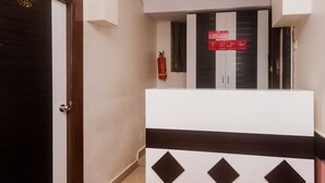 A hallway with a closed door marked '105', a fire extinguisher, and a sign indicating Wi-Fi availability. - OYO 22039 Hotel Bkc Grand (Mumbai)