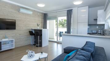 Superior-Apartment, 2 Schlafzimmer, Terrasse (C2a) | Wohnzimmer | 55-Zoll-Flachbildfernseher mit Satellitenempfang, Fernseher