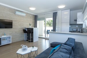 Apartamento superior, 2 quartos, terraço (C2a) | Sala de estar | TV de tela plana 55 polegadas com canais via satélite, TV
