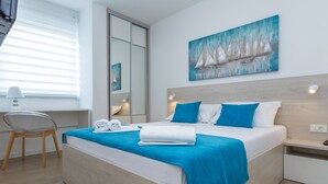 A modern hotel room with a bed, a desk, and a chair. - Apartments & Rooms Villa Casia (Novalja)