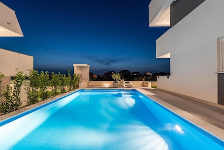 Una piscina al aire libre de temporada, sombrillas