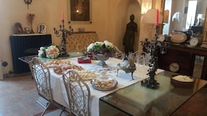 A dining table set with various food items, a statue, and decorative objects. - B&B Palazzo de Matteis (San Severo)