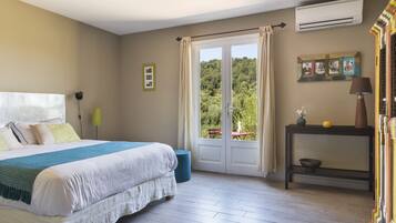 A bedroom with a bed, a bedside table, an air conditioner, and a window with curtains.