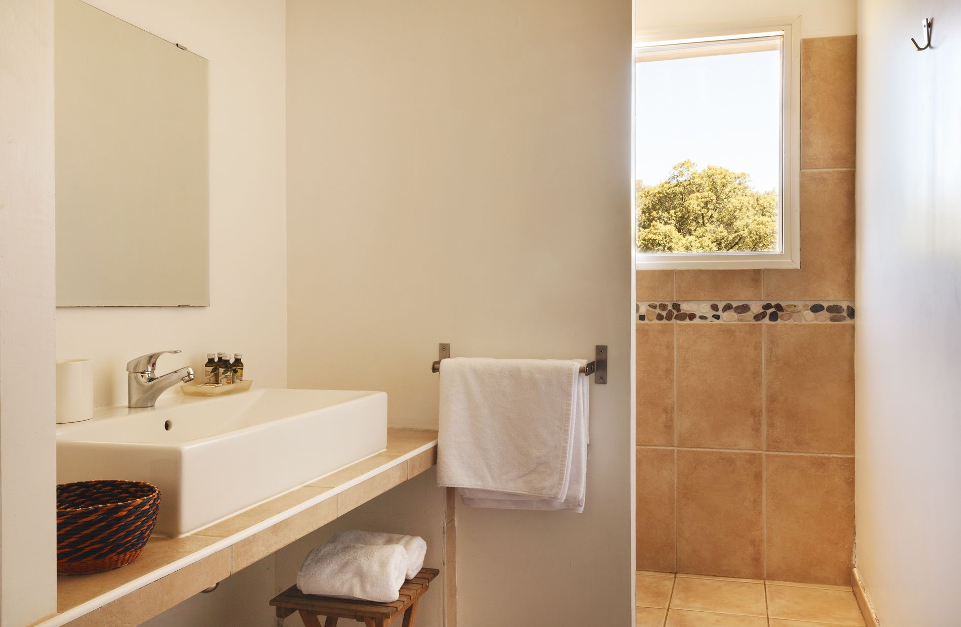 Un baño con lavamanos, espejo y ventana.
