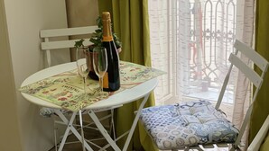 A table with a bottle of champagne, two glasses, and a potted plant. - Joy Naples (Naples)