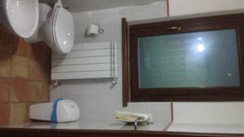 A bathroom with a toilet, bidet, and sink.
