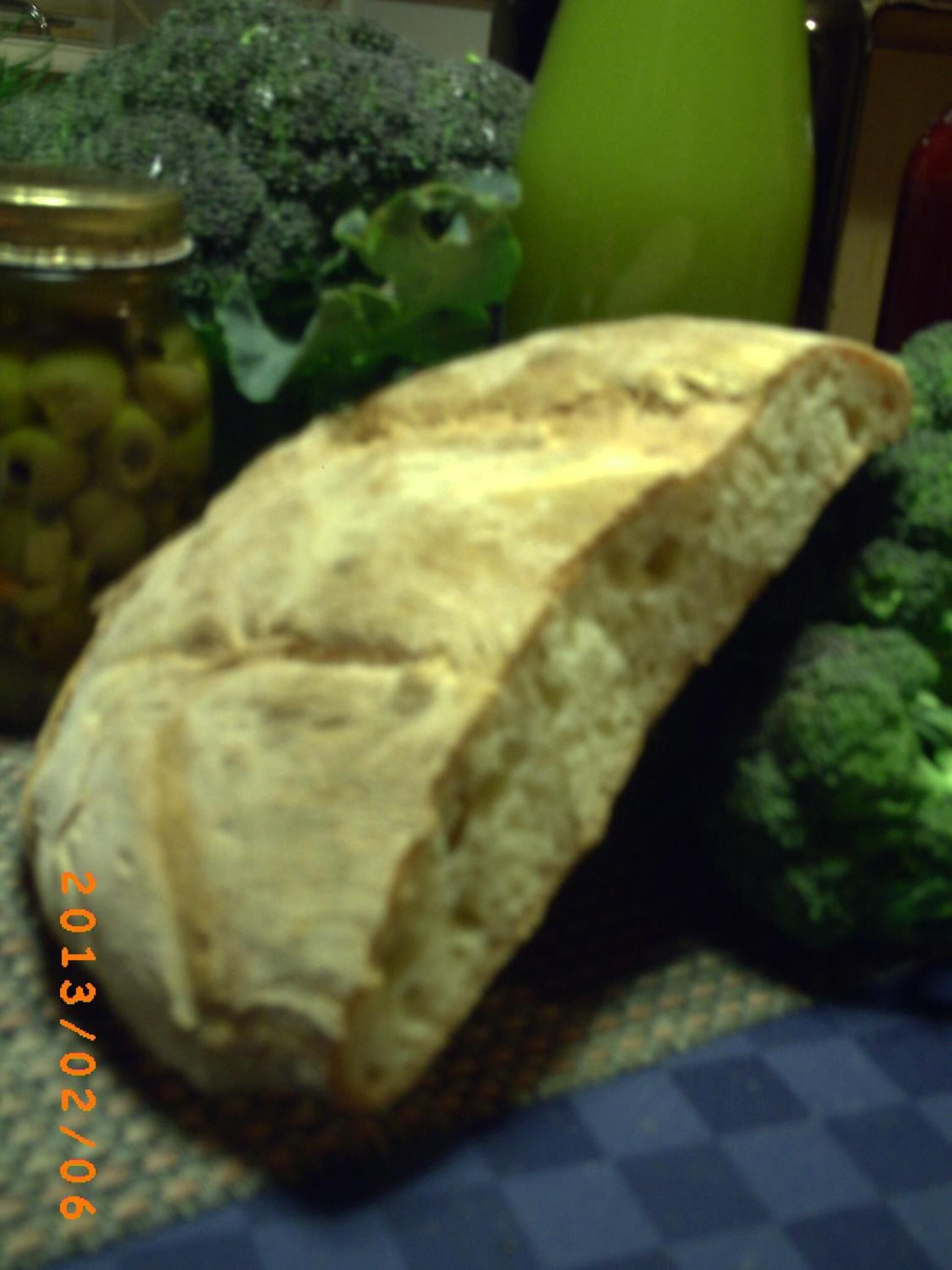 A loaf of bread on a table with a checkered tablecloth.
