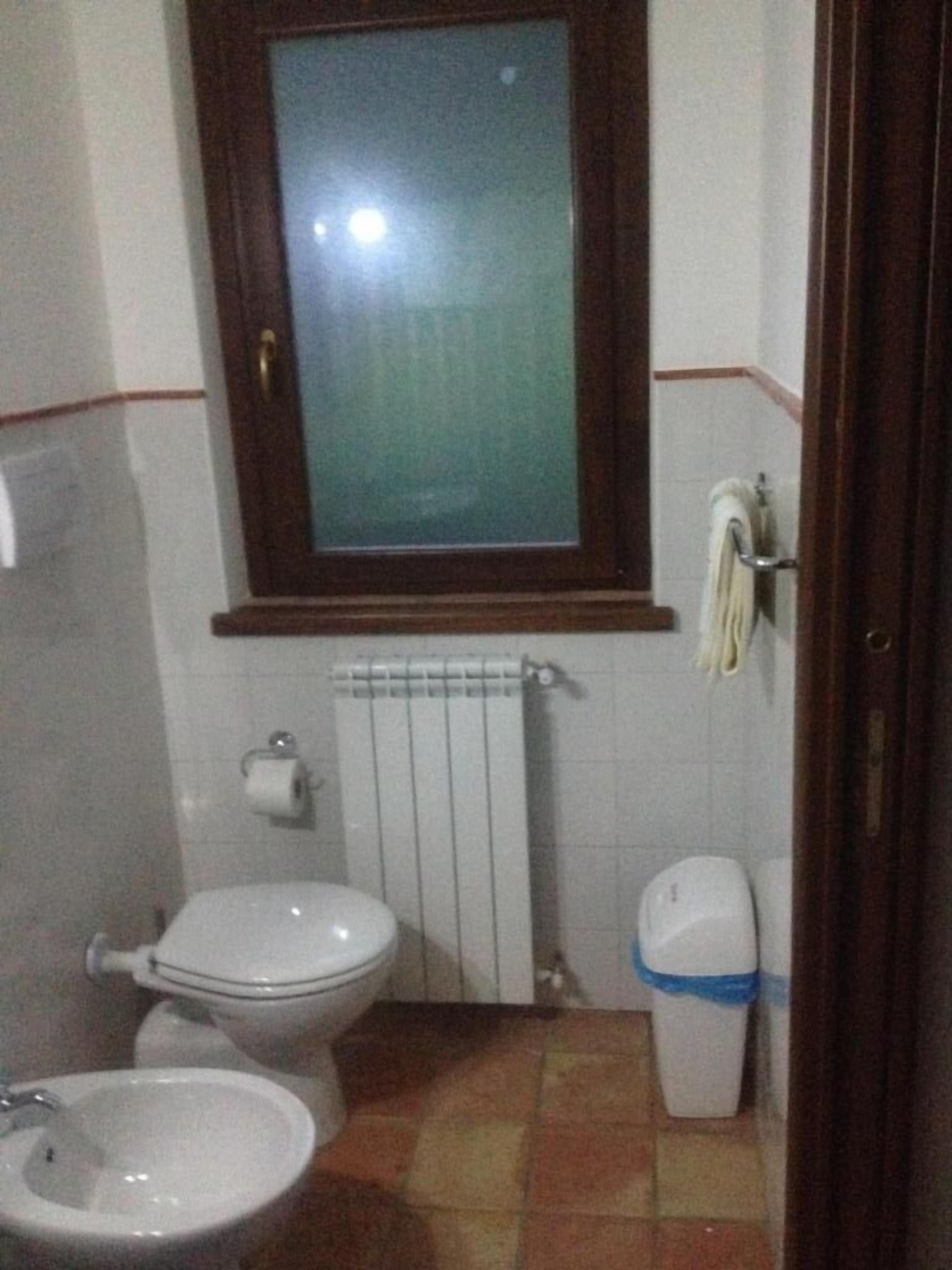 A small bathroom with a toilet, bidet, and sink.