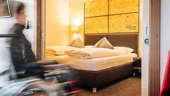 A hotel room with a wooden headboard, two beds, and a nightstand with a lamp. - Guthof Lutz Appartement mit kostenlosen Sommerbergbahnticket Mai bis Oktober (Schattwald)
