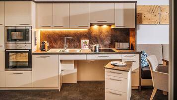 A modern kitchen with built-in appliances, a central island, and a seating area.