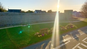 Un mur de pierre avec un espace gazonné et un banc.