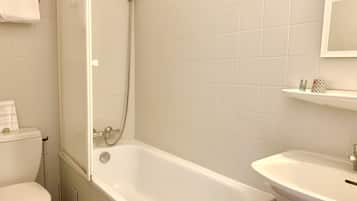 A bathroom with a bathtub, toilet, and sink.