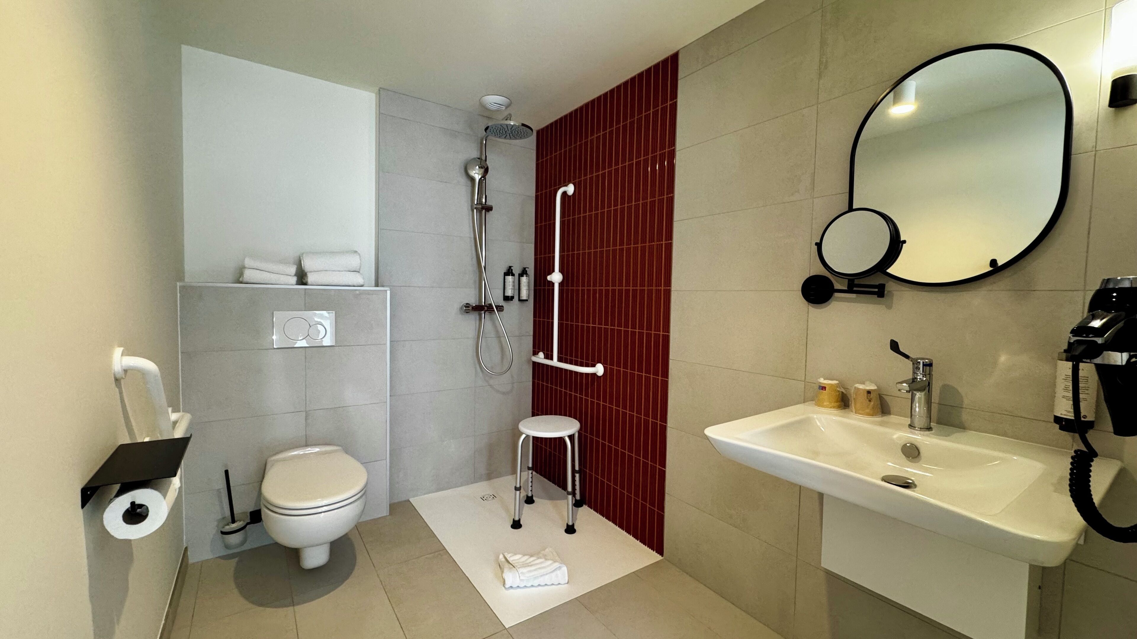 Un baño moderno con inodoro, bidé, ducha, lavamanos y un espejo.