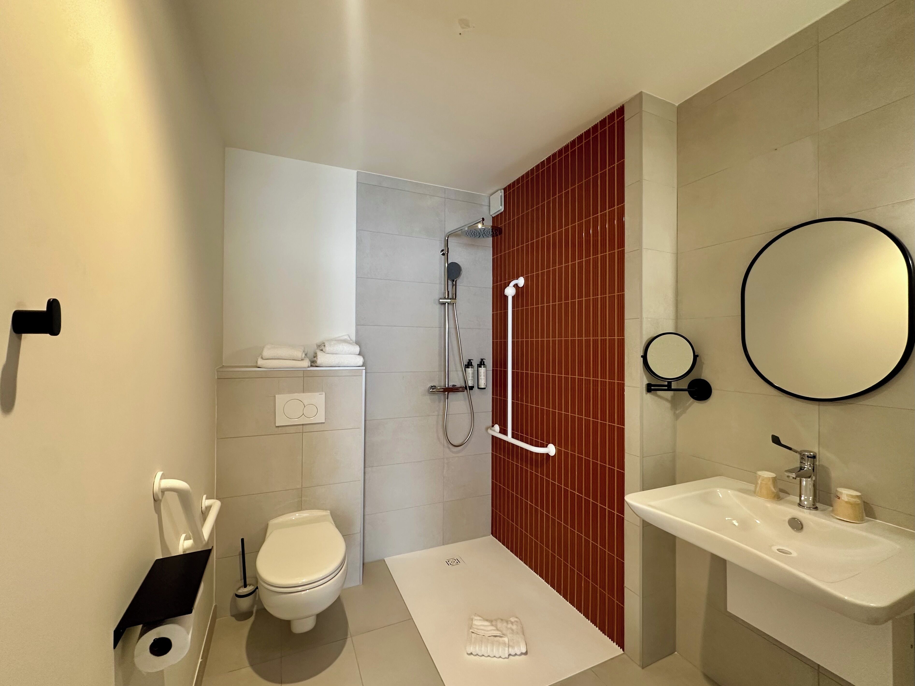 Un baño moderno con inodoro, ducha y lavabo.