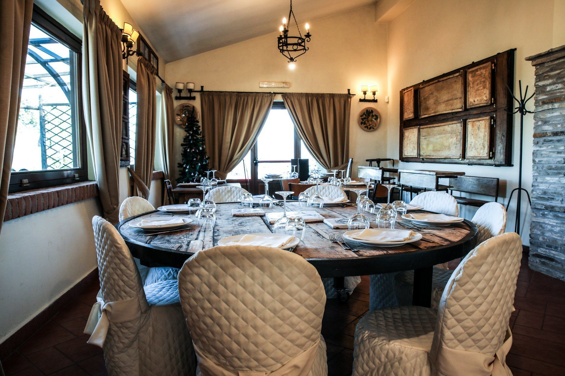 Un comedor con una mesa redonda dispuesta para seis personas, rodeada de seis sillas acolchadas.