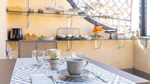 Une table mise pour le petit-déjeuner, avec de la vaisselle et une plante en pot.