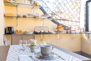 A breakfast setup with a table, glassware, and a potted plant.