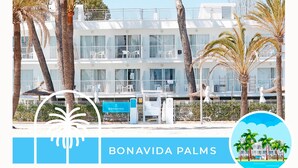 A beachfront hotel with multiple balconies, palm trees, and a sign reading "BONAVIDA PALMS".