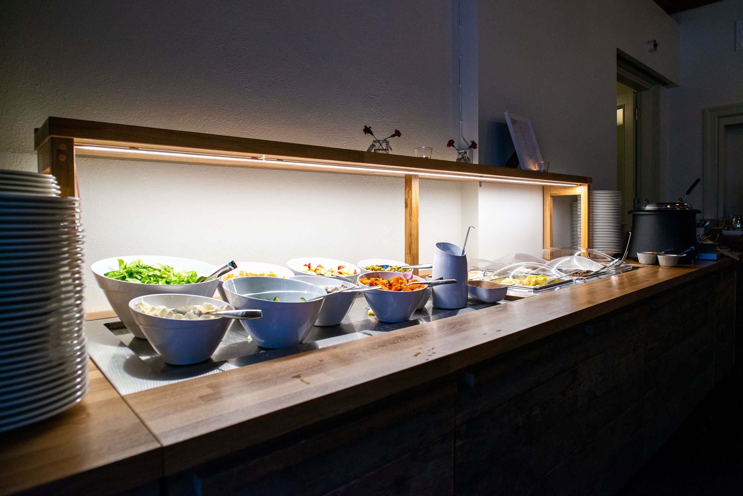 A buffet setup with various food items and serving utensils.