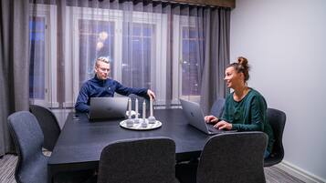 A conference room with a long table, two laptops, and a candle centerpiece.