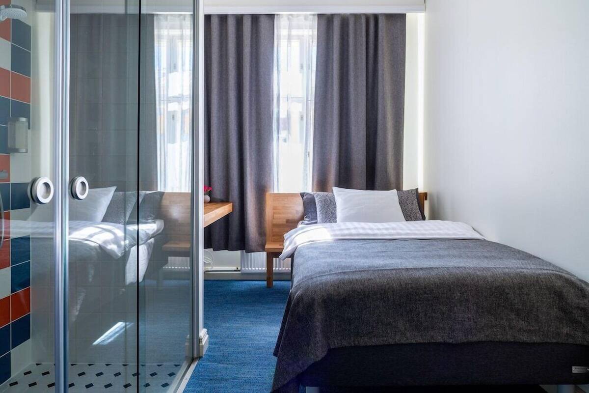 Una habitación de hotel con cama, escritorio y silla.