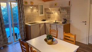 Cozinha compacta com pia, fogão e área de refeições.