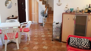 A compact living space with a dining area, kitchenette, and staircase. - Holiday Home Spektar (Novalja)