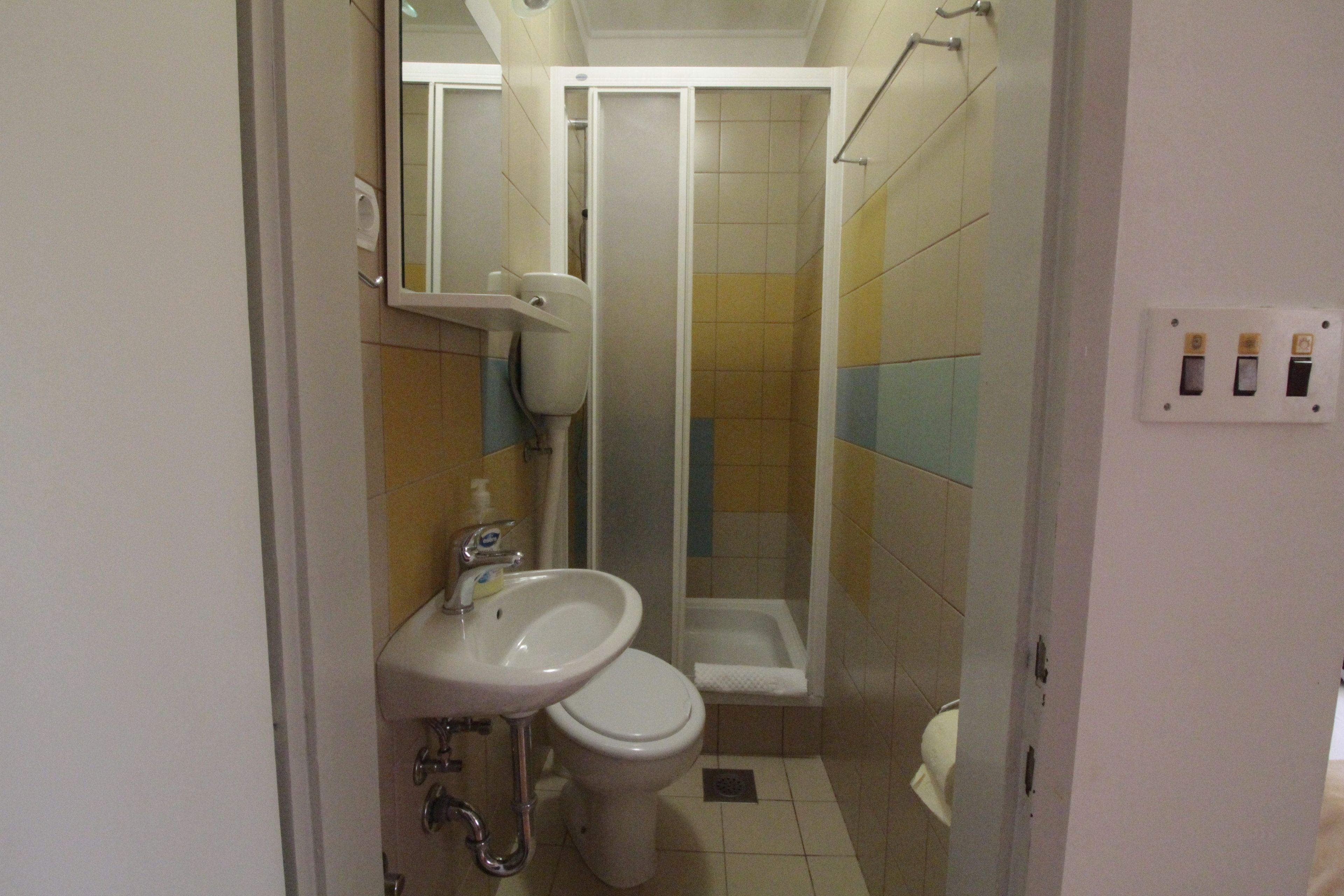 A bathroom with a sink, toilet, and shower.