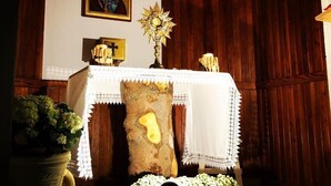 A religious icon, a candle holder, and a wooden cross on a table with a white lace tablecloth. - Rifugio La Capanna (Claviere)
